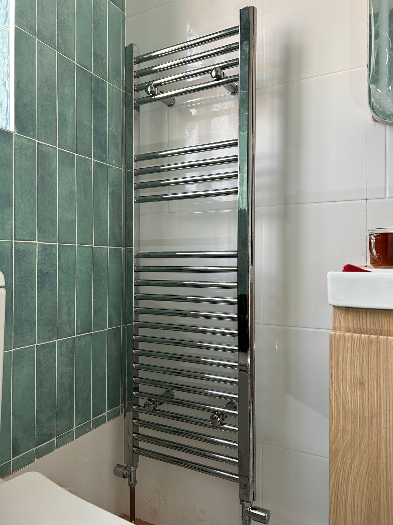 Chrome heated towel rail installed by Flow Plus Plumbing